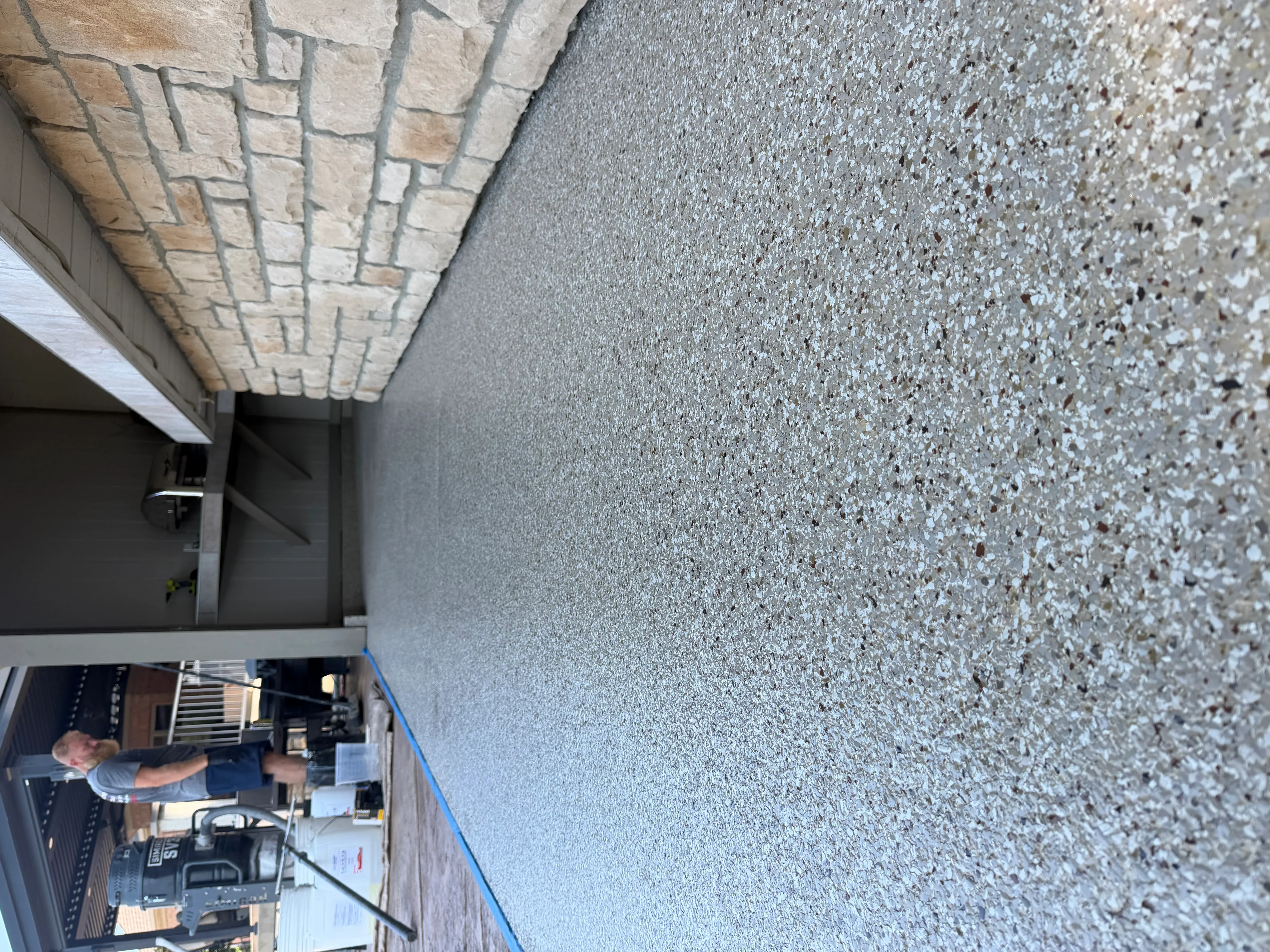 Textured gray concrete wall coating with aggregate finish on commercial exterior