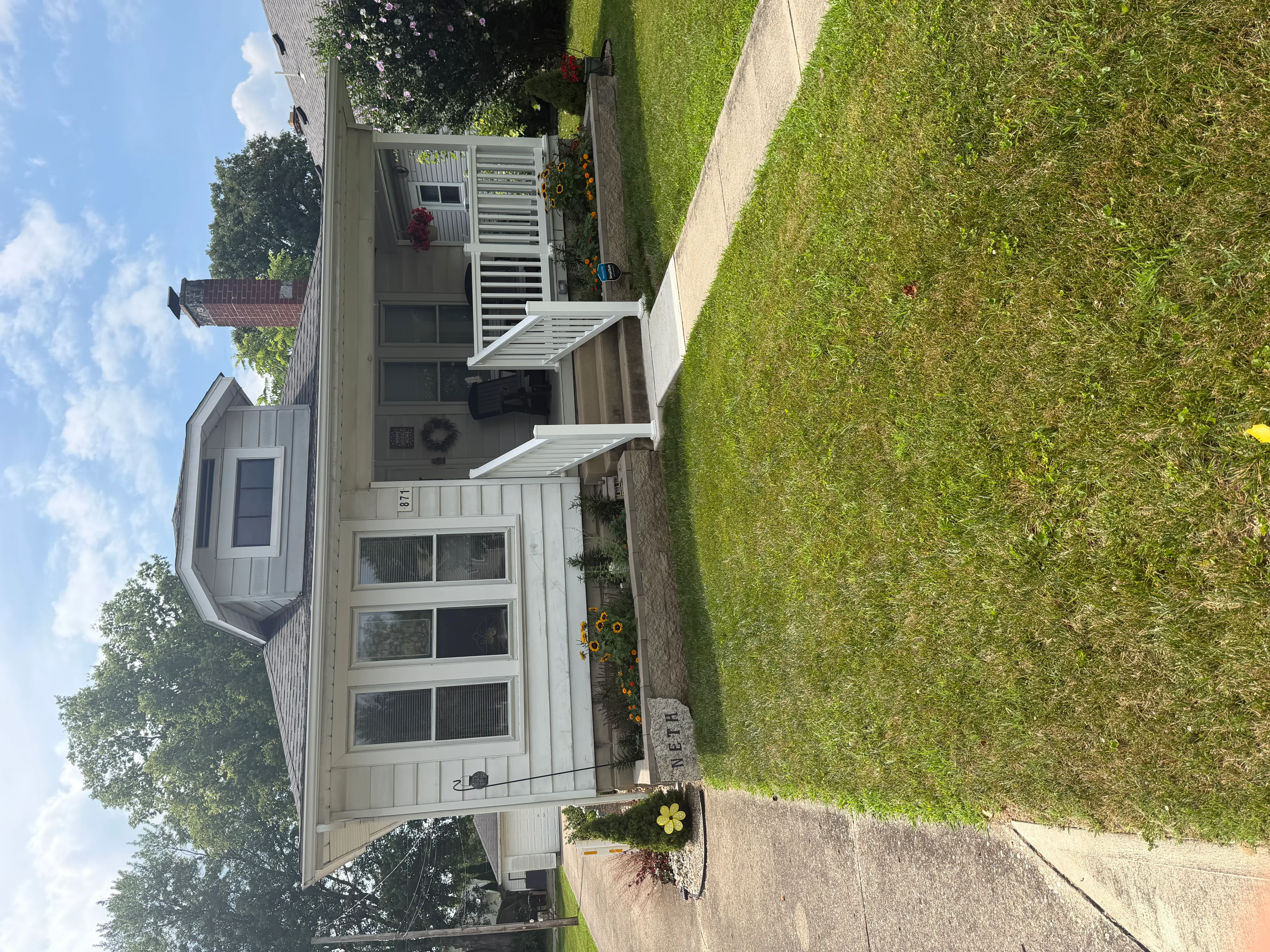 Freshly painted residential home with white trim, neutral siding, and painted deck railings